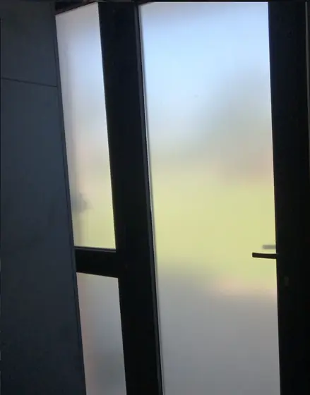 Esmerilado liso. Puerta de vidrio cubierta con esmerilado liso para dar privacidad.